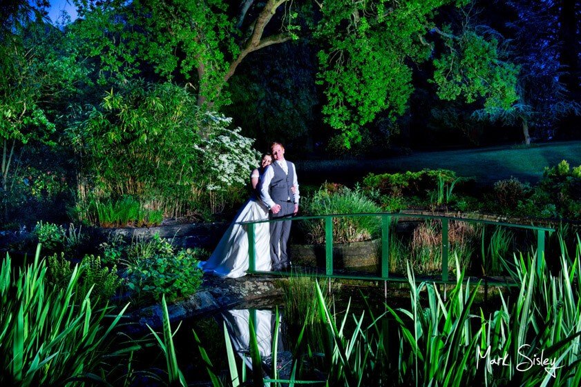 Bride and groom on bridge at night - Mark Sisley Photography