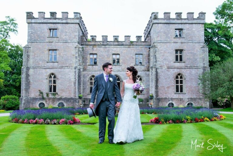 Clearwell Castle wedding image of the newlyweds strolling in front of the castle