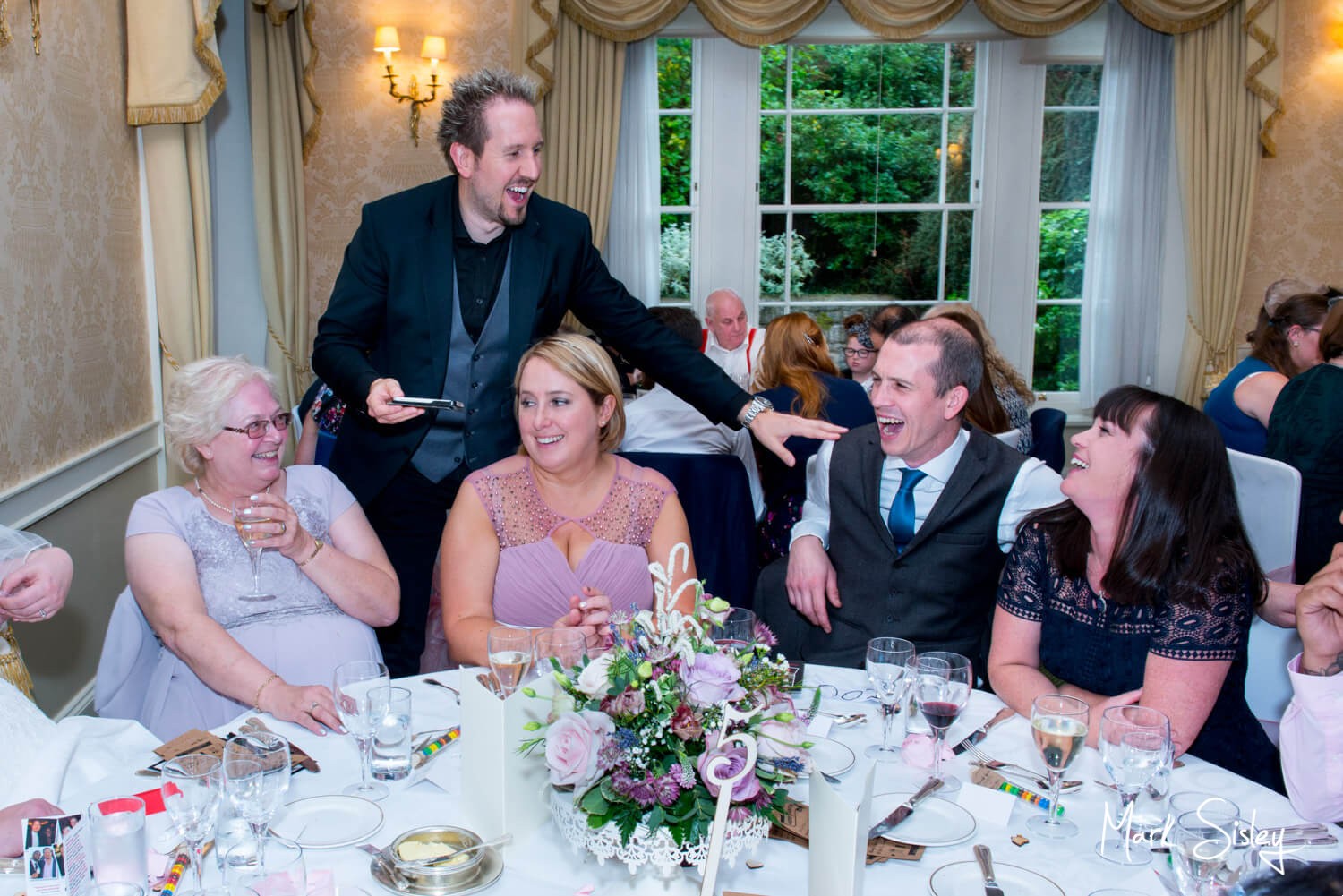 Hartwell House autumn wedding photography of the magician working the room