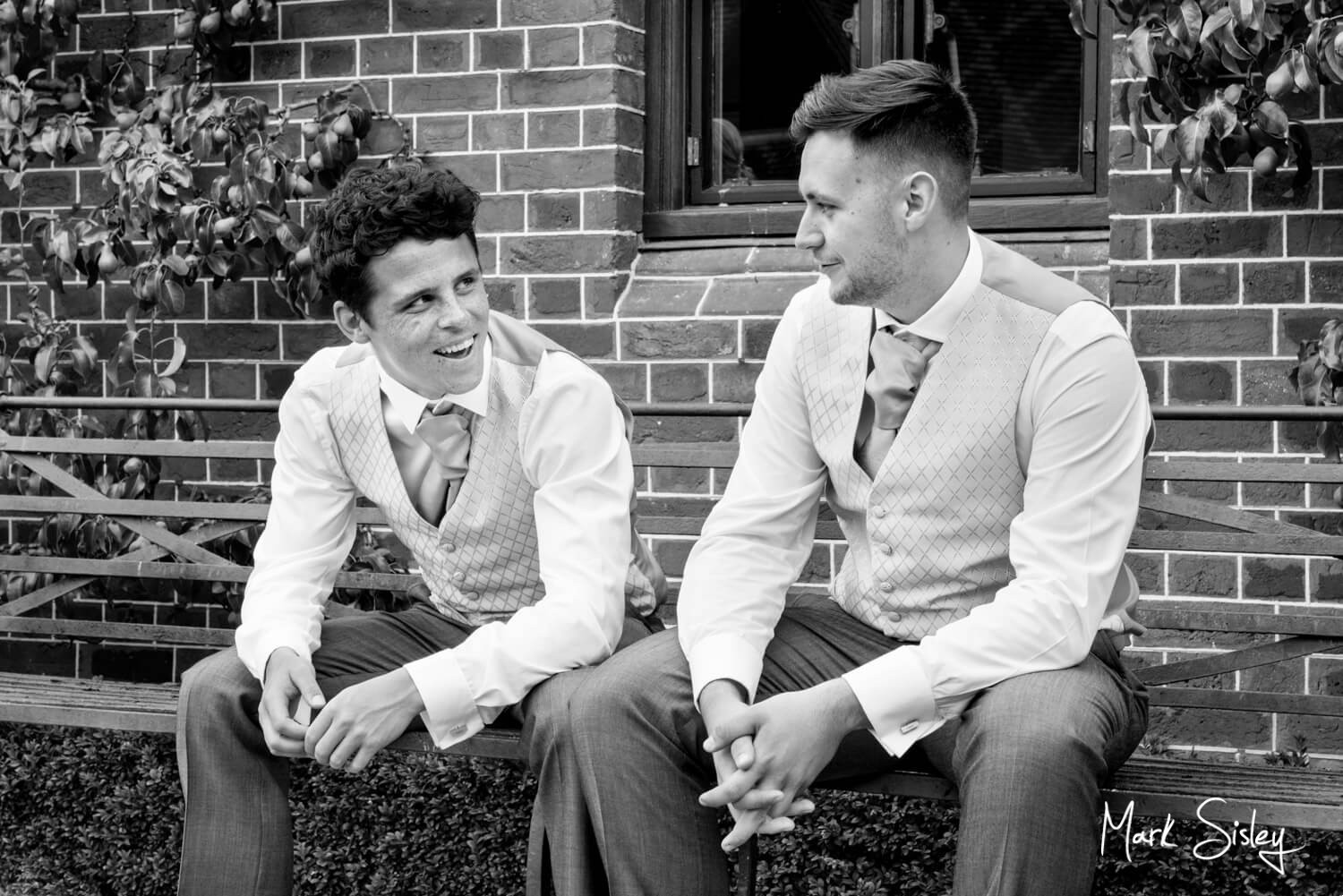 Informal reportage shot of ushers chatting at wedding at The Dairy Waddesdon Manor