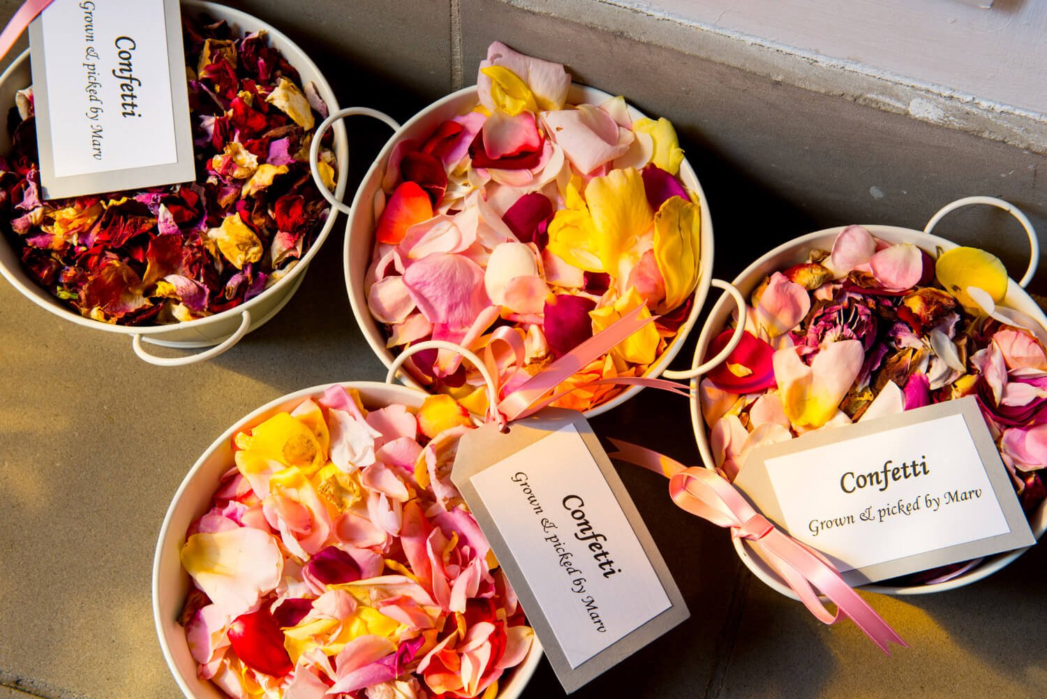 Rose petals by the stained glass window at Missenden Abbey wedding