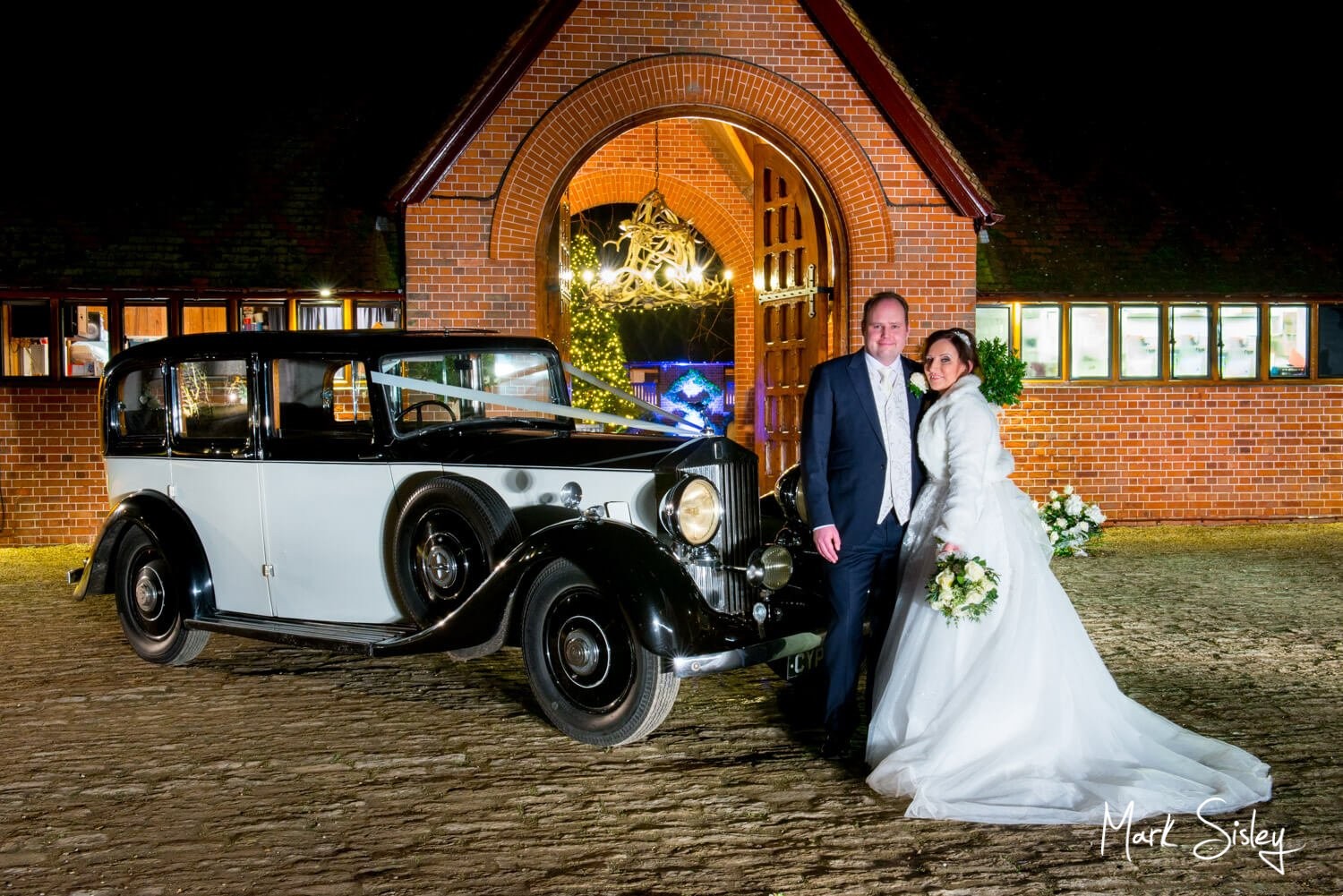 Waddesdon Dairy Christmas wedding pose with the newlyweds glitzy car