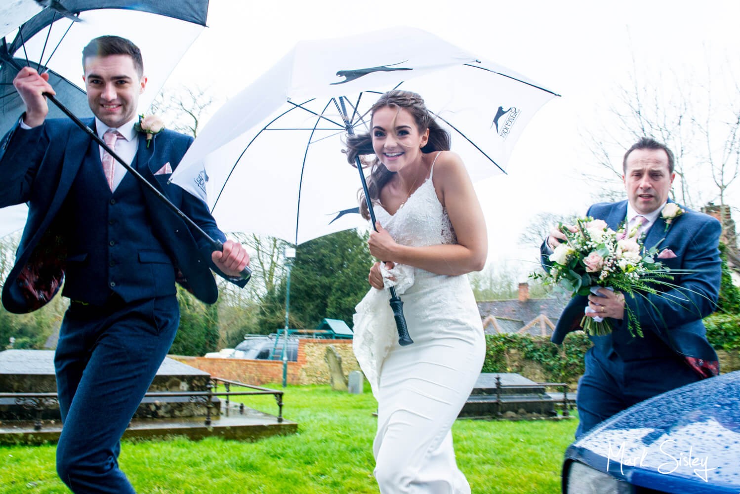 The bride arrives at the church for her Waddesdon Manor wedding during Storm Dennis