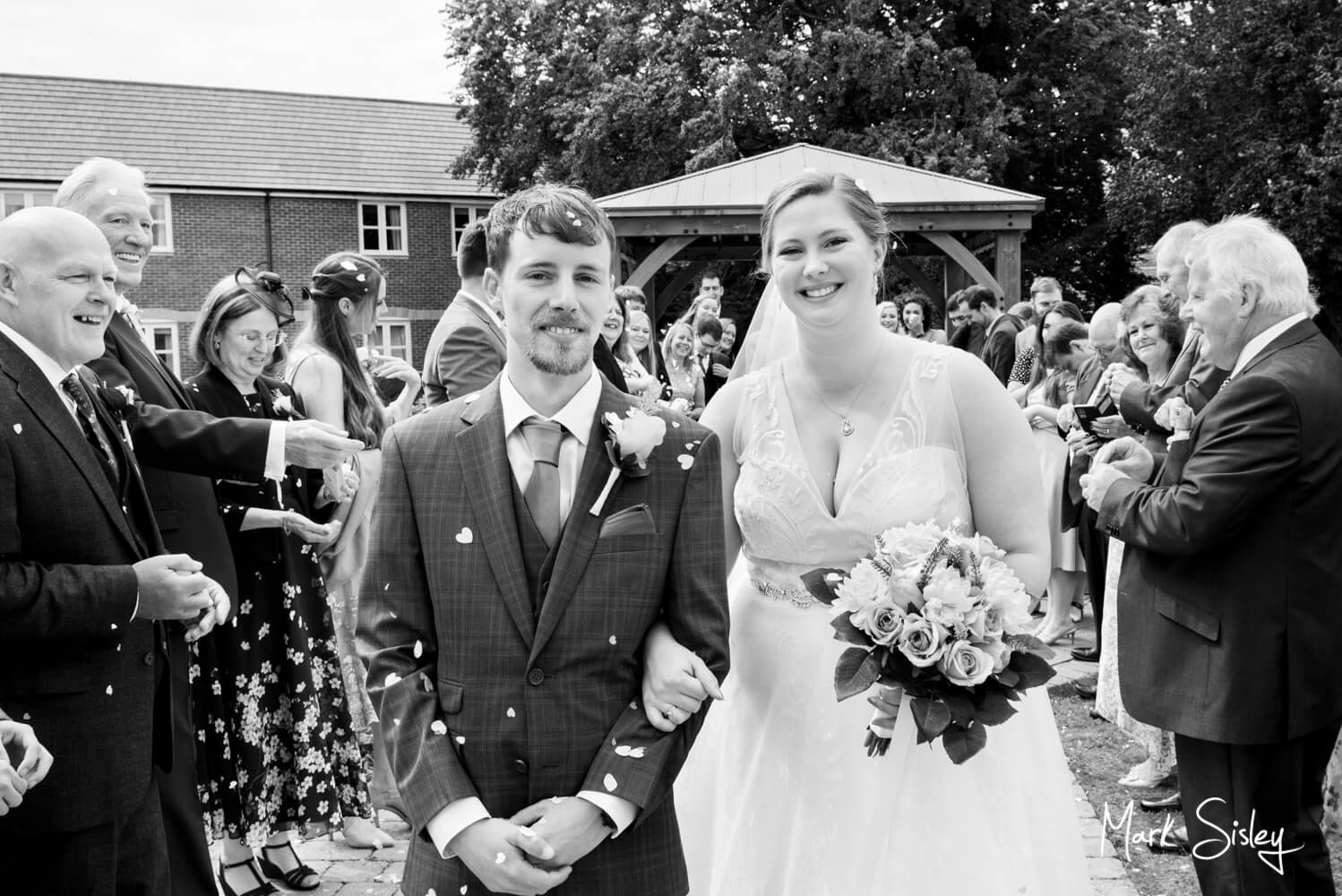 The happy newlyweds walking through their wedding confetti aisle at the Lambert Hotel near Thame - a perfect opportunity for some fun photography