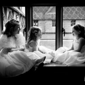 Black and white silhouette image of young bridesmaids in window at The Dairy Waddesdon wedding
