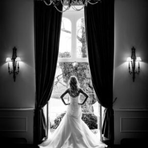 Black and white silhouette image of bride in window at Taplow House Hotel wedding