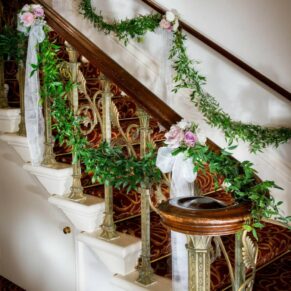 Floral arrangements on stairs at Taplow House wedding