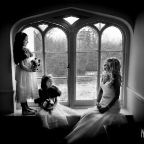Black and white window-lit photography of bride and bridesmaids at Taplow House Hotel wedding