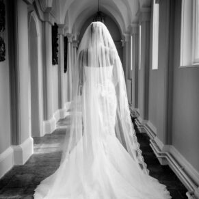 Black and white image of bride in Gothic passage at Hampden House winter wedding