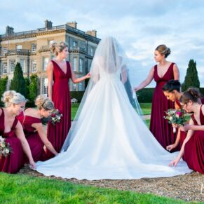 Hedsor House wedding photographs of the bridesmaids adjusting the bride's gown