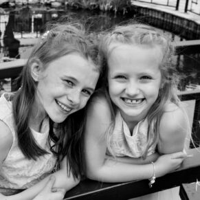 Photography of two smiling flower girls in the gardens at this Sopwell House summer  wedding