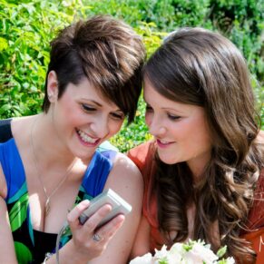 Photography of two ladies enjoying some online banter with a friend who's not at the celebrations for this Bay Tree Hotel in Burford 