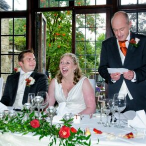 Lively wedding photography of the speeches in progress in the dining room at the Bay Tree Hotel in Burford