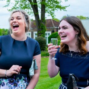 Candid wedding photography of two ladies laughing away during the summer drinks reception at this Beaumont Estate wedding 