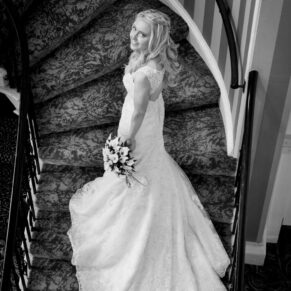 Photography of the bride on the staircase captured from above with her gown perfectly positioned on the staircase at her Beaumont Estate wedding     