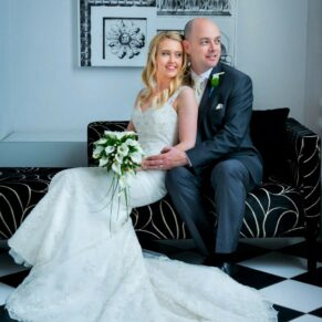 Photography of the newlyweds sat on a sofa by the window in the White House at their Beaumont Estate wedding  