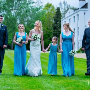 Photography of the bridal party taking a relaxed stroll in the lush gardens at their Beaumont Estate summer wedding 