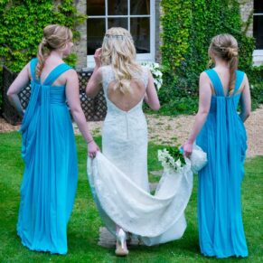Photography of the bride strolling with her bridesmaids through the gardens of the Beaumont Estate towards the main building on her wedding day  