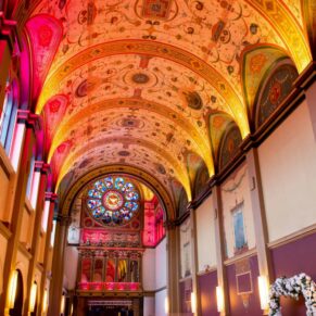 Interior photography of the historic Beaumont Estate chapel captured in all its glory with up-lighters at this Old Windsor wedding celebration
