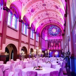 The Victorian chapel illuminated with colourful uplighters for the evening wedding reception