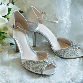 The bride's gorgeous wedding shoes and bouquet placed delicately onto her dress before the ceremony at her Beaumont Estate wedding