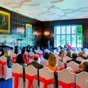 The oak panelled ceremony room during a wedding service with wonderful window light illuminating the room