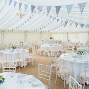 The marquee interior setup with lots of bunting just prior to the wedding breakfast at Dorton House in Buckinghamshire