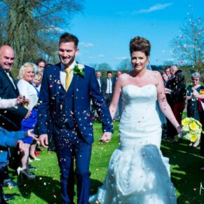 The newlyweds dash through the colourful confetti aisle at their Dorton House summer wedding  