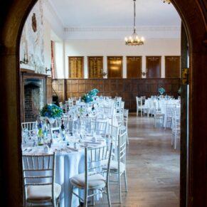 Setup for the wedding breakfast captured through an archway into the dining room at this Dorton House wedding 