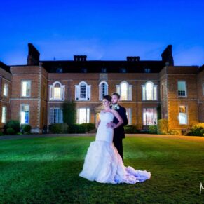 The newlyweds captured at dusk with some additional floodlighting to create the wow factor for this pose at their Dorton House wedding 