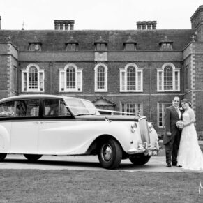 The newlyweds with their gorgeous wedding car at the front of Dorton House 