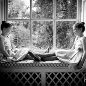 Flower girls enjoying a chat in this feature window at Hartwell House wedding 