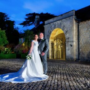 Atmospheric night shot of the bride and groom outside The Hartwell Court buildings at Hartwell House 