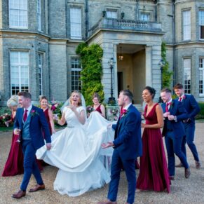 The bridal party walking away from the house to explore the fabulous grounds at Hedsor 
