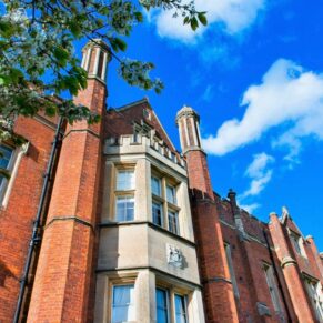 The dramatic exterior of the main house on a glorious blue sky wedding day  