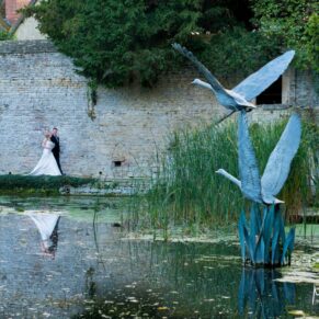 The newlyweds stroll beside the lake at their Le Manoir Aux Quat Saisons summer wedding 