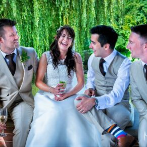 Candid wedding photography of the bride with the ushers chatting and giggling away in the pavilion