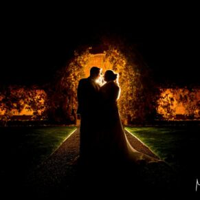 Dramatic silhouette pose of the newlyweds in The Dairy courtyard at night for their Christmas wedding