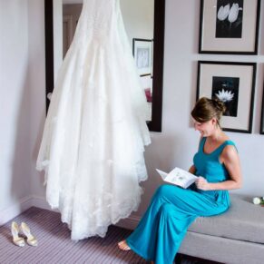 Wokefield Estate Berkshire Wedding Photography - the bride sat beside her gown in the bedroom