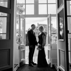 A dramatic silhouette pose of the newlyweds in the main entrance doorway of Saint Michael's Manor