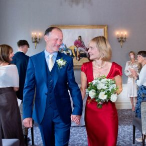 The smiling newlyweds exit their indoor civil ceremony at Saint Michael's Manor