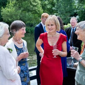 The happy bride relaxing beside the lake with some of her family at their Saint Michael's Manor wedding 
