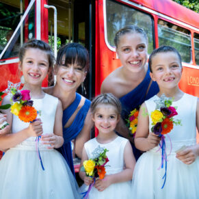 The bridesmaids pose informally outside the red London double decker bus