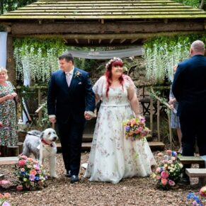 The exit of the bride and groom from their woodland ceremony captured at their Buckinghamshire outdoor venueg