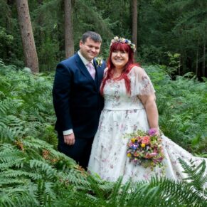 Woodland wedding pose of the newlyweds captured in the ferns at their Buckinghamshire outdoor reception venue