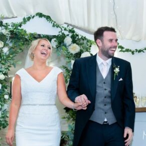 The newlyweds captured at The Grange, Northwood entering the marquee