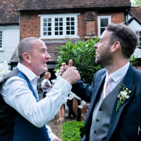 Candid moment of the groom and a friend captured at The Grange, Northwood 