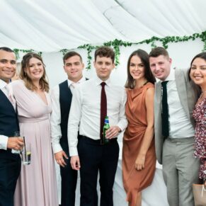 A group of friends pose for the camera in the marquee, captured at The Grange, Northwood 