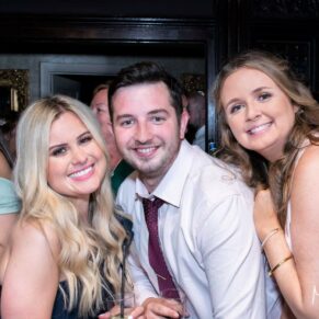 Wedding guests pose for the camera during the wedding evening reception, captured at The Grange, Northwood 
