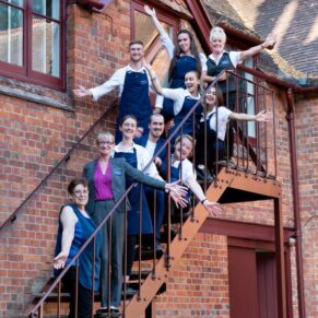 The staff pose on the steps of the Five Arrows Hotel for a fun image after an exhausting wedding day 